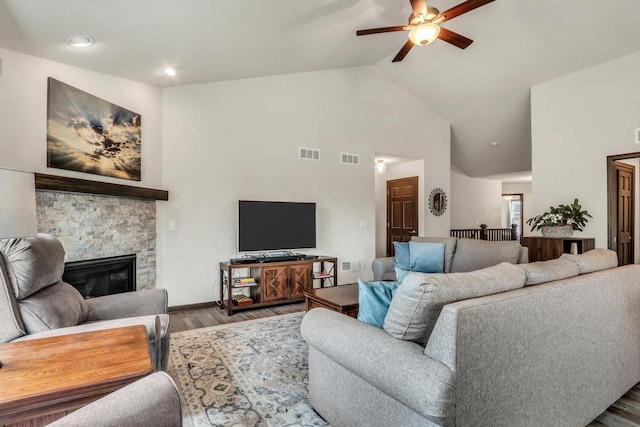 5208 Briarwood Cir, Racine, WI 53402 - living room featuring ceiling fan, wood finished floors, high vaulted ceiling, a stone fireplace, and baseboards