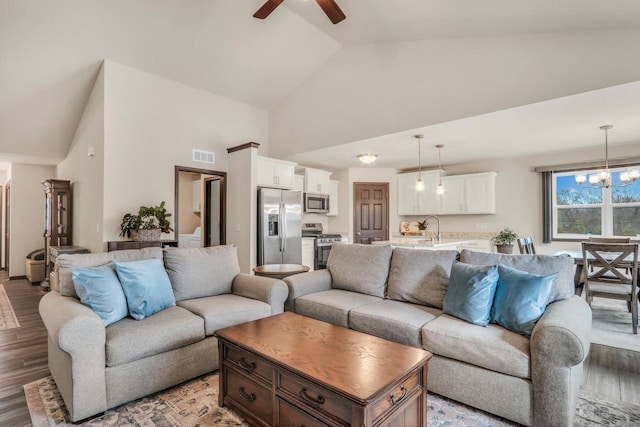 5208 Briarwood Cir, Racine, WI 53402 - living room featuring high vaulted ceiling, a ceiling fan, light wood-style floors, and a chandelier