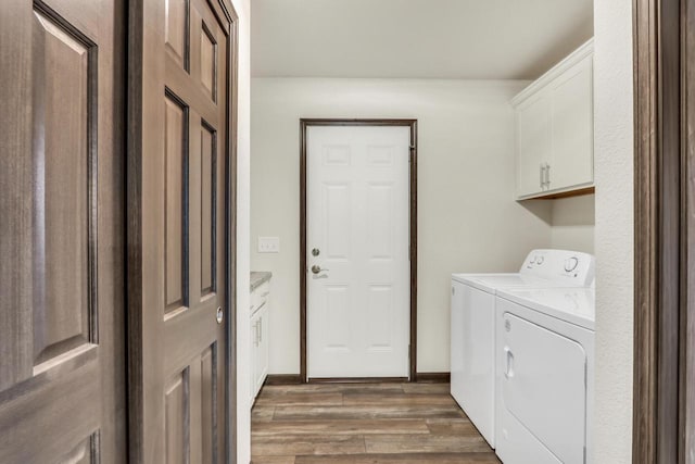 5208 Briarwood Cir, Racine, WI 53402 - laundry room featuring washing machine and clothes dryer, cabinet space, and wood finished floors