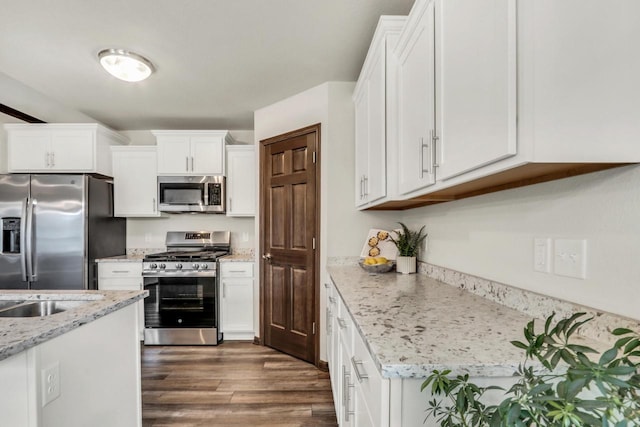 5208 Briarwood Cir, Racine, WI 53402 - kitchen featuring stainless steel appliances, dark wood-type flooring, white cabinets, and light stone counters