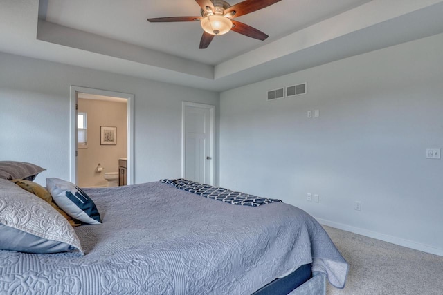 bedroom featuring carpet flooring, baseboards, a raised ceiling, connected bathroom, and a ceiling fan