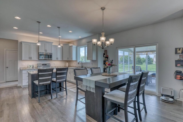 dining room featuring light wood-style flooring, a chandelier, recessed lighting, and baseboards