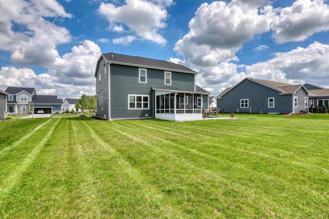 rear view of property with a sunroom and a lawn