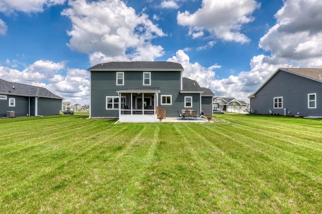 back of property with a sunroom, a patio, a lawn, and central air condition unit