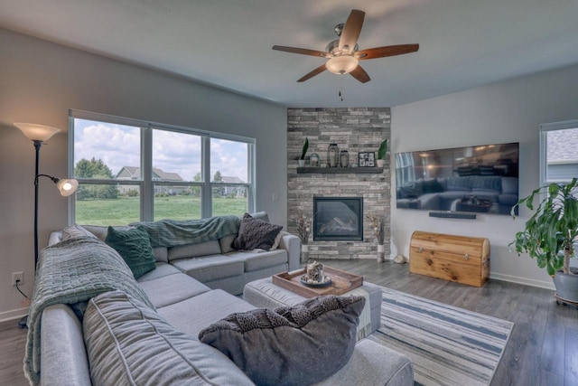 living area with ceiling fan, baseboards, wood finished floors, and a fireplace