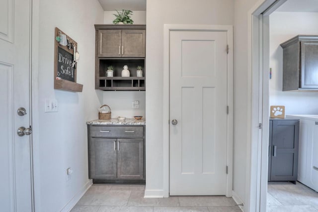 bar featuring baseboards and light tile patterned floors