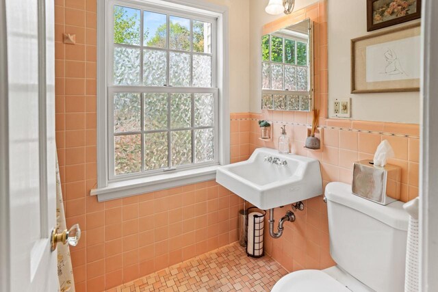 2577 N 89th St, Wauwatosa, WI 53226 - half bathroom with tile walls, a sink, toilet, and a wainscoted wall