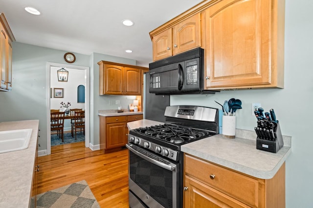 2577 N 89th St, Wauwatosa, WI 53226 - kitchen with stainless steel range with gas cooktop, black microwave, light wood-style flooring, light countertops, and recessed lighting
