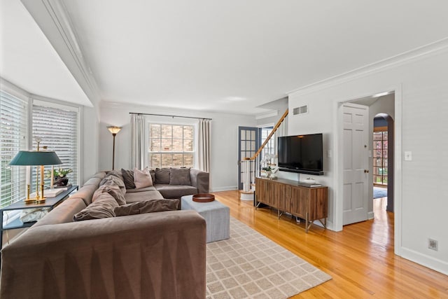 2577 N 89th St, Wauwatosa, WI 53226 - living area featuring crown molding, arched walkways, light wood-type flooring, baseboards, and stairway
