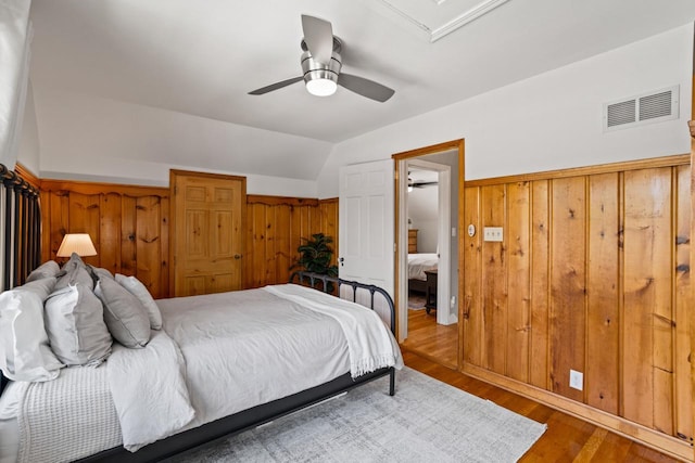 2577 N 89th St, Wauwatosa, WI 53226 - bedroom featuring wood finished floors, wood walls, a wainscoted wall, and ceiling fan