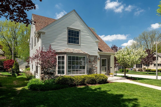 2577 N 89th St, Wauwatosa, WI 53226 - traditional-style home featuring stone siding, a front yard, and a shingled roof