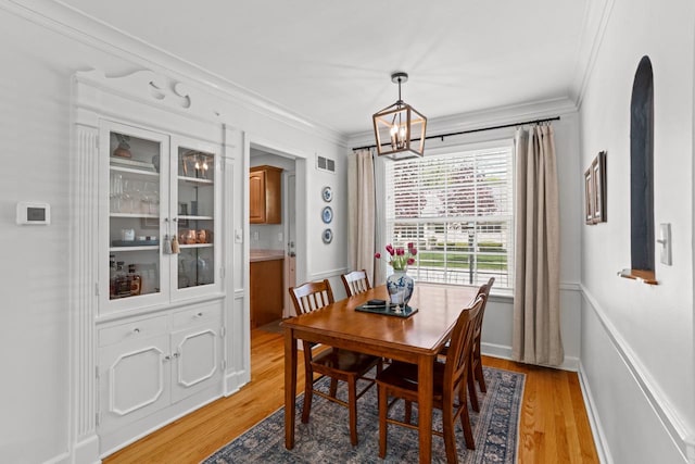 2577 N 89th St, Wauwatosa, WI 53226 - dining room featuring crown molding, a chandelier, and light wood-style flooring