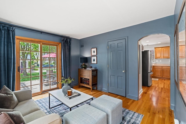 2577 N 89th St, Wauwatosa, WI 53226 - living area with arched walkways, light wood-style flooring, and baseboards