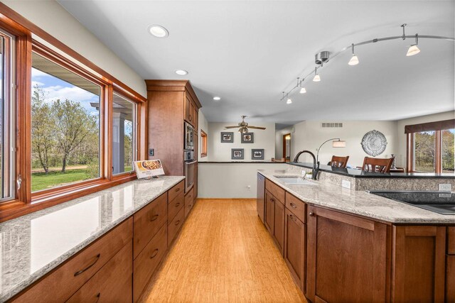 169003 Shorewood Dr, Rosholt, WI 54473 - kitchen featuring a sink, appliances with stainless steel finishes, brown cabinets, light wood-style floors, and recessed lighting