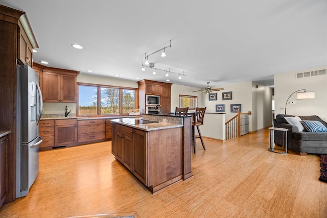 169003 Shorewood Dr, Rosholt, WI 54473 - kitchen with appliances with stainless steel finishes, open floor plan, light wood-type flooring, ceiling fan, and a kitchen island