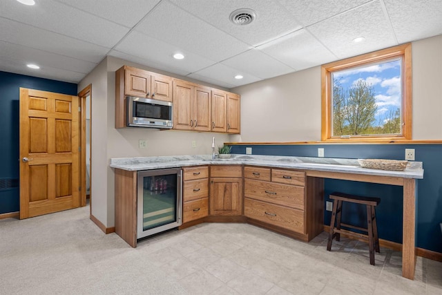 169003 Shorewood Dr, Rosholt, WI 54473 - kitchen featuring wine cooler, stainless steel microwave, a sink, a drop ceiling, and light stone countertops