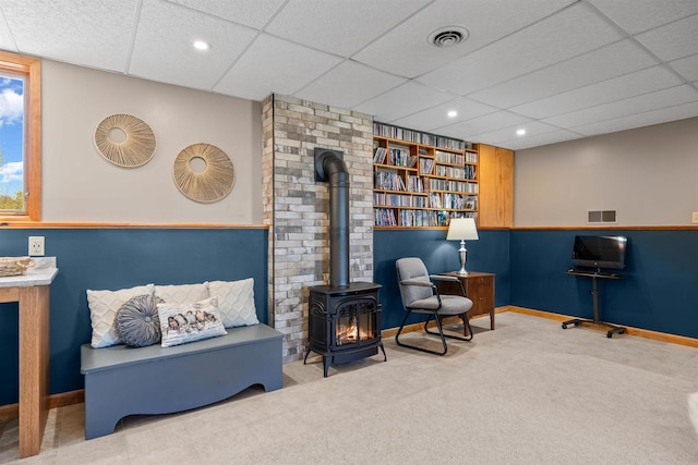 169003 Shorewood Dr, Rosholt, WI 54473 - sitting room featuring a wood stove, a paneled ceiling, baseboards, carpet flooring, and recessed lighting