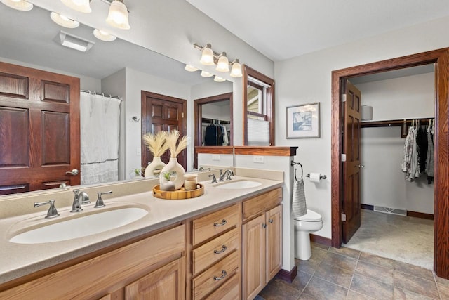 N5798 Lakeview Dr, Green Lake, WI 54941 - bathroom with double vanity, toilet, a spacious closet, and baseboards