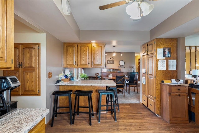 912 S 3rd Ave, Edgar, WI 54426 - kitchen featuring wood finished floors, light countertops, a peninsula, and a breakfast bar area
