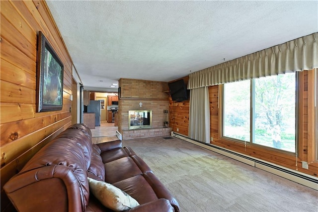 811 Russell St, Grantsburg, WI 54840 - carpeted living room with a textured ceiling, a baseboard radiator, wooden walls, and a brick fireplace