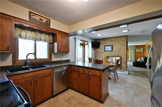 811 Russell St, Grantsburg, WI 54840 - kitchen featuring appliances with stainless steel finishes, a sink, open floor plan, dark countertops, and a peninsula