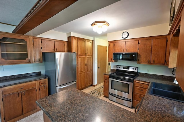 811 Russell St, Grantsburg, WI 54840 - kitchen featuring appliances with stainless steel finishes, brown cabinets, dark countertops, and a sink