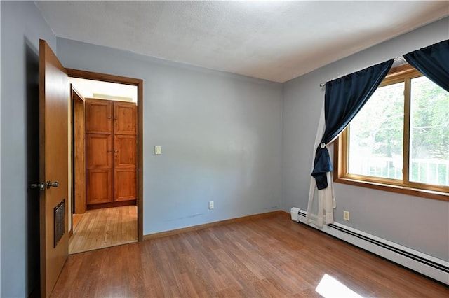 811 Russell St, Grantsburg, WI 54840 - unfurnished room with baseboard heating, wood finished floors, and baseboards