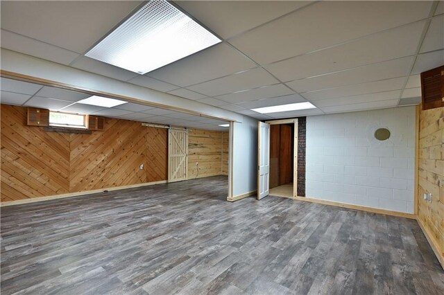 811 Russell St, Grantsburg, WI 54840 - below grade area featuring wood finished floors, a drop ceiling, wood walls, and concrete block wall