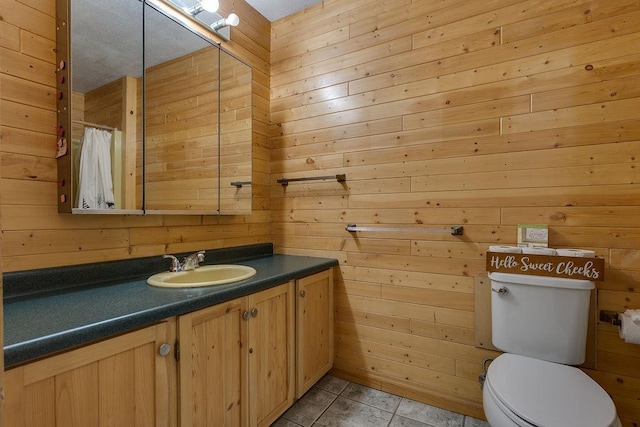 14 S 3rd St, Darien, WI 53114 - bathroom featuring wooden walls, vanity, toilet, and tile patterned flooring