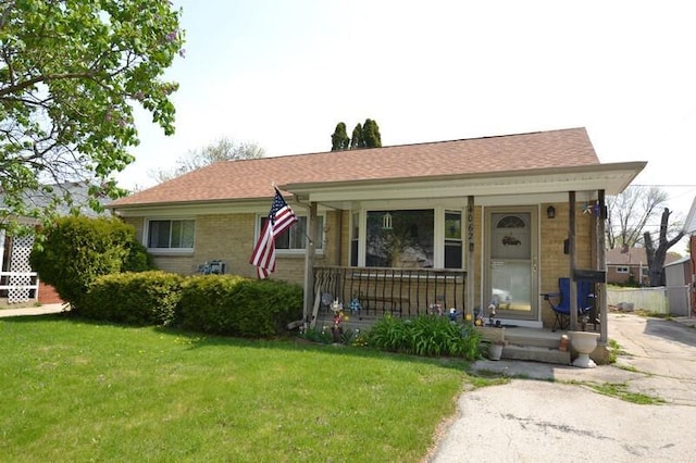 4062 S Troy Ave, Saint Francis, WI 53235 - view of front facade with covered porch, a front yard, and brick siding