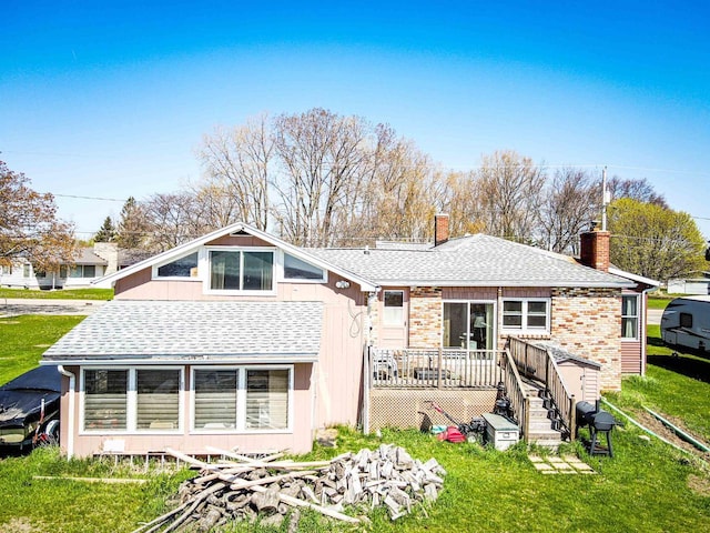 103 W Bay Shore St, Marinette, WI 54143 - back of house featuring a shingled roof, a deck, a chimney, and a yard