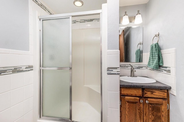 11915 Wedgewood Ln, Darlington, WI 53530 - bathroom with a shower stall, vanity, tile walls, and backsplash