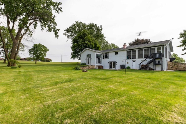 11915 Wedgewood Ln, Darlington, WI 53530 - back of property with a chimney, a yard, stairs, a sunroom, and central air condition unit