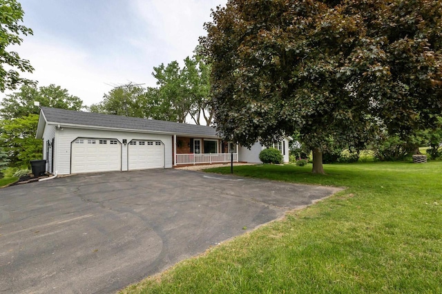 11915 Wedgewood Ln, Darlington, WI 53530 - view of front of home featuring an attached garage, asphalt driveway, a front yard, and covered porch