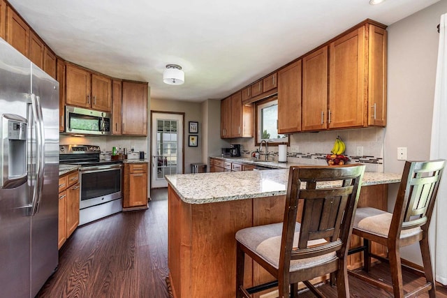 11915 Wedgewood Ln, Darlington, WI 53530 - kitchen featuring stainless steel appliances, a peninsula, brown cabinetry, and recessed lighting