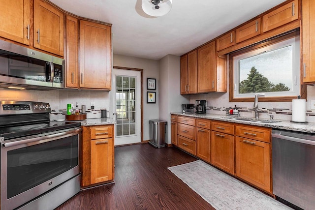 11915 Wedgewood Ln, Darlington, WI 53530 - kitchen with stainless steel appliances, a sink, brown cabinets, and backsplash