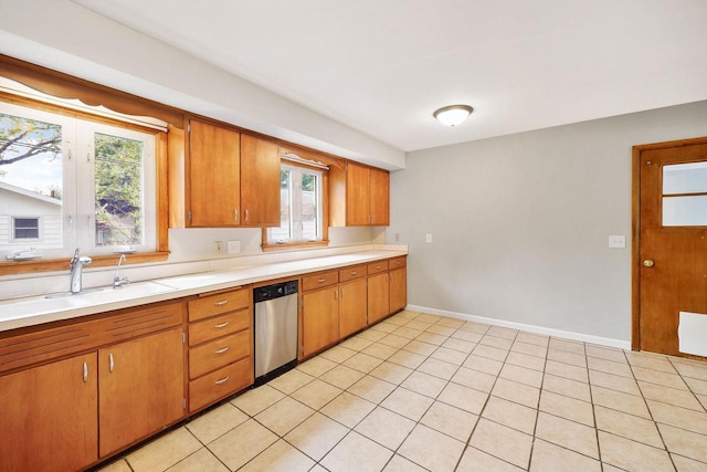 605 Douglas Trl, Madison, WI 53716 - kitchen featuring stainless steel dishwasher, a sink, light countertops, brown cabinets, and plenty of natural light