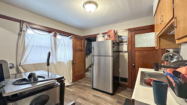 5561 N 40th St, Milwaukee, WI 53209 - kitchen featuring freestanding refrigerator, range with electric stovetop, light wood-type flooring, an office area, and brown cabinets