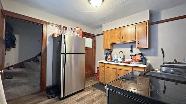 5561 N 40th St, Milwaukee, WI 53209 - kitchen featuring freestanding refrigerator, a sink, light wood-type flooring, black electric range oven, and light countertops