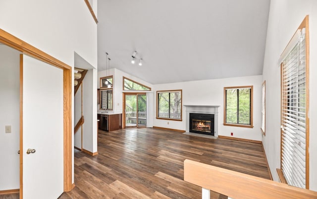901 Duck Pond Rd, Fontana, WI 53125 - unfurnished living room featuring lofted ceiling, a fireplace with flush hearth, dark wood-style flooring, and baseboards
