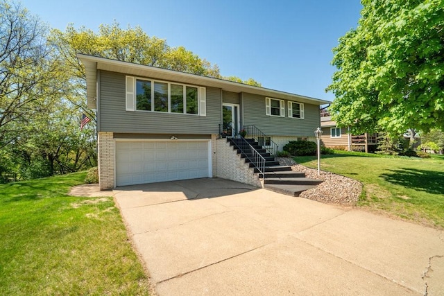 bi-level home featuring brick siding, an attached garage, driveway, and a front yard