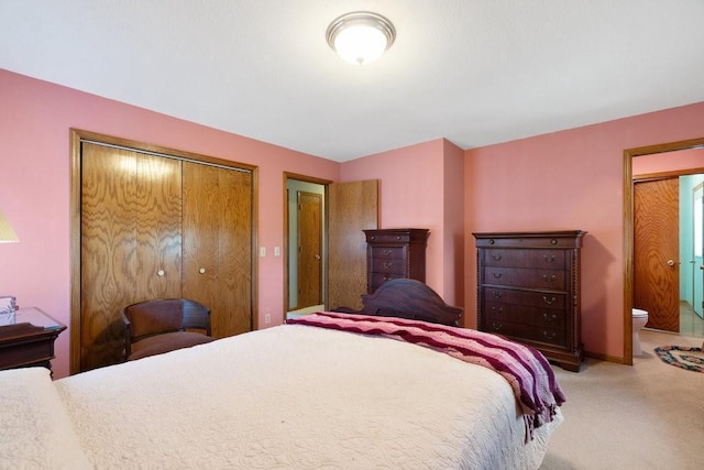 carpeted bedroom with a closet and connected bathroom