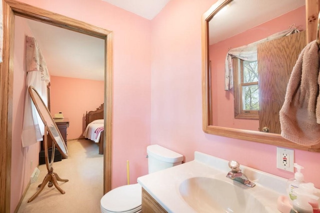 ensuite bathroom featuring toilet and vanity