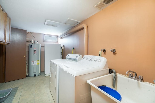 laundry room featuring electric water heater, a sink, attic access, washing machine and dryer, and light tile patterned floors