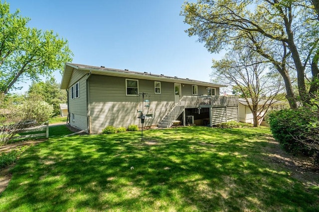 rear view of property with stairway, a yard, and a wooden deck