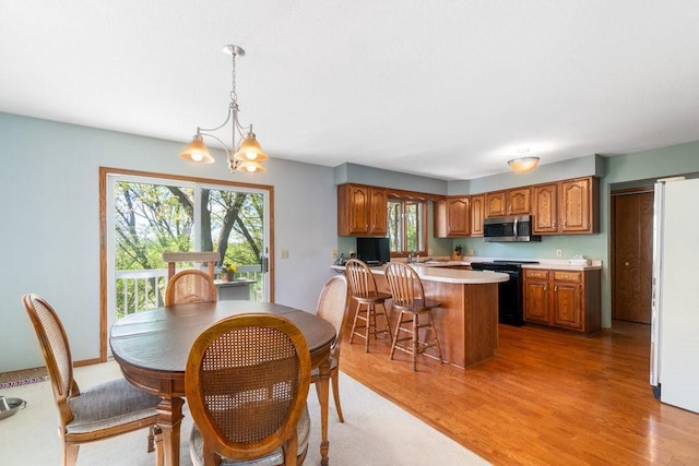 dining area featuring light wood-style flooring and a chandelier