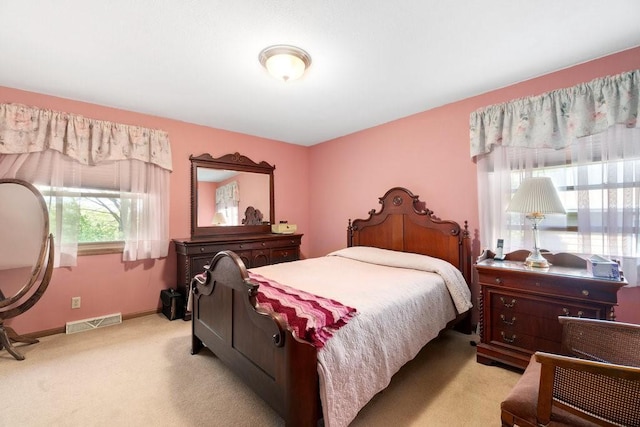 bedroom featuring light colored carpet and baseboards