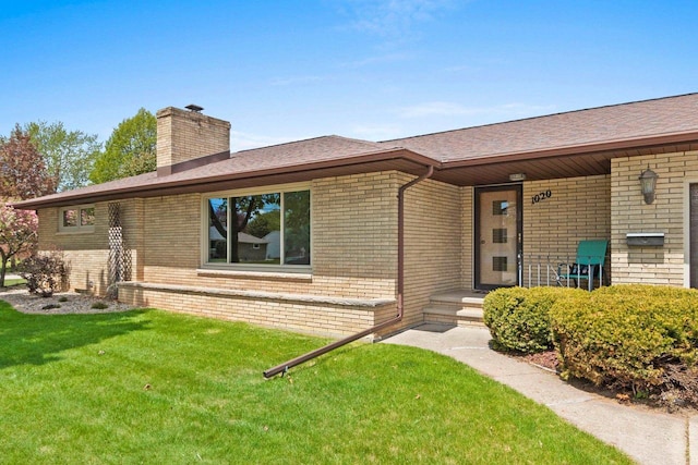 1020 W 3rd St, Kimberly, WI 54136 - property entrance featuring brick siding, a chimney, a lawn, and a shingled roof