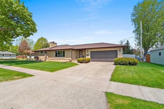 1020 W 3rd St, Kimberly, WI 54136 - view of front of property featuring a garage, brick siding, a chimney, and driveway