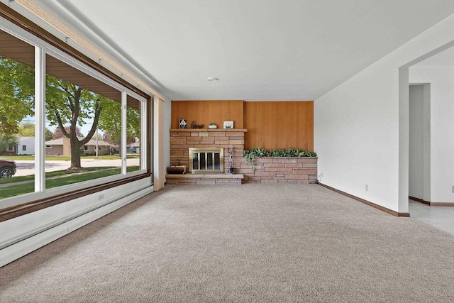 1020 W 3rd St, Kimberly, WI 54136 - unfurnished living room featuring wood walls, a stone fireplace, carpet flooring, and baseboards